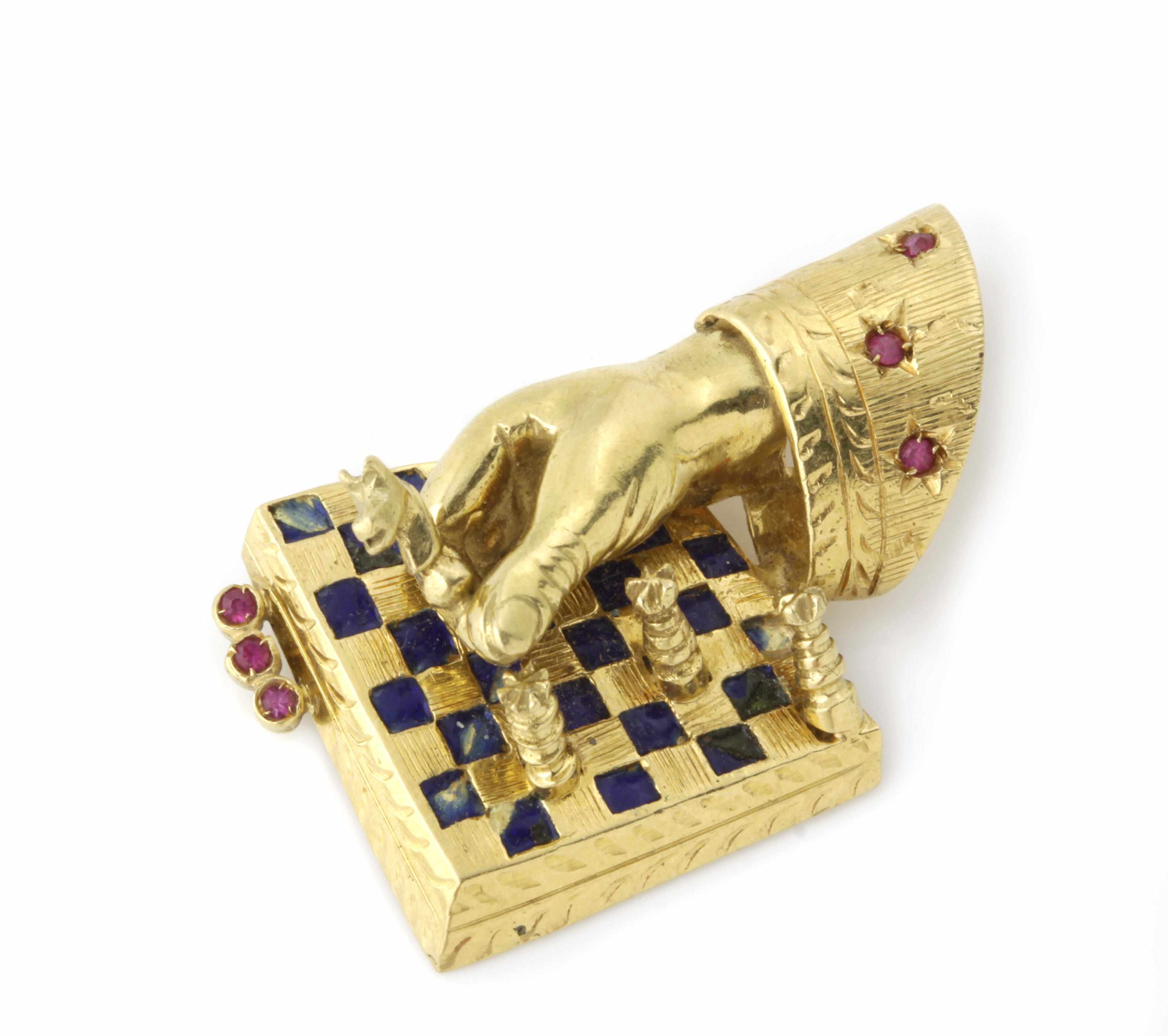 Appraisal: A red stone and enamel ''chess player'' brooch mounted in