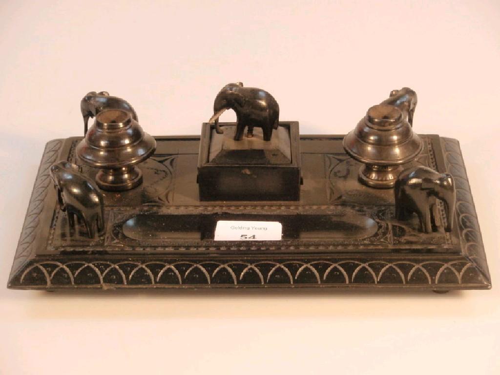 Appraisal: An Indian ebony ink stand having four carved elephant corners