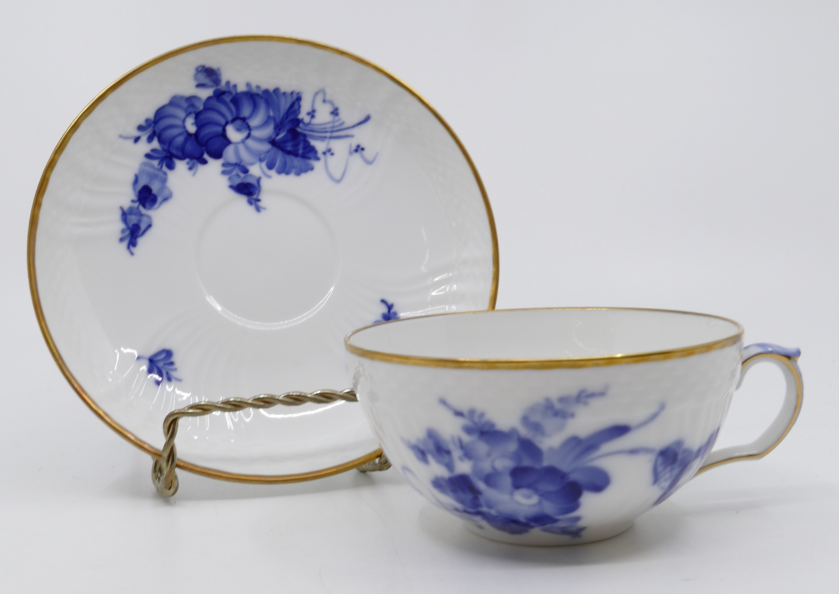 Appraisal: pc Royal Copenhagen Blue Flowers Curved Flat Cups Saucers Gilt