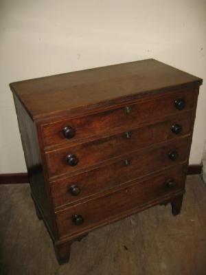 Appraisal: AN OAK CHEST of four graduated cockbeaded drawers with turned