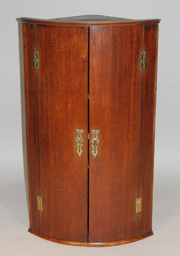 Appraisal: An thC oak barrel fronted corner cupboard the two front