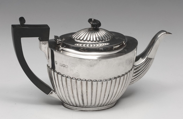 Appraisal: A SILVER TEAPOT oval with fluted body and hardwood handle