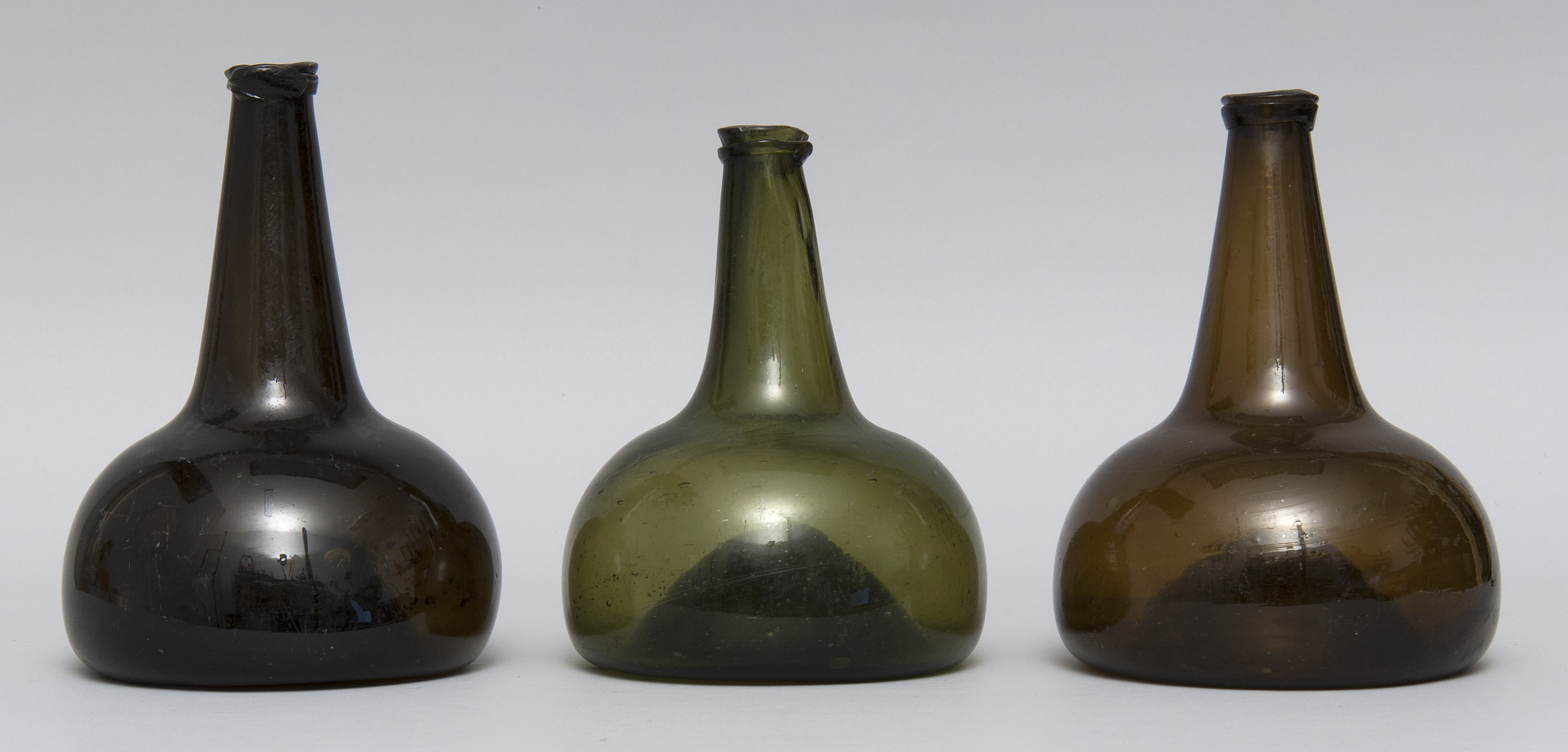 Appraisal: THREE FREE-BLOWN GLASS LIQUOR BOTTLES Late th Early th CenturyIn