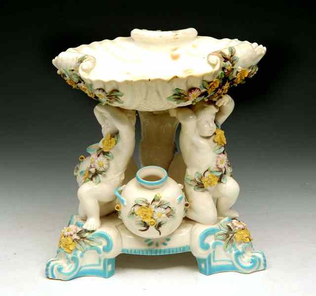 Appraisal: A MINTON STYLE FLORAL ENCRUSTED CENTREPIECE in the form of