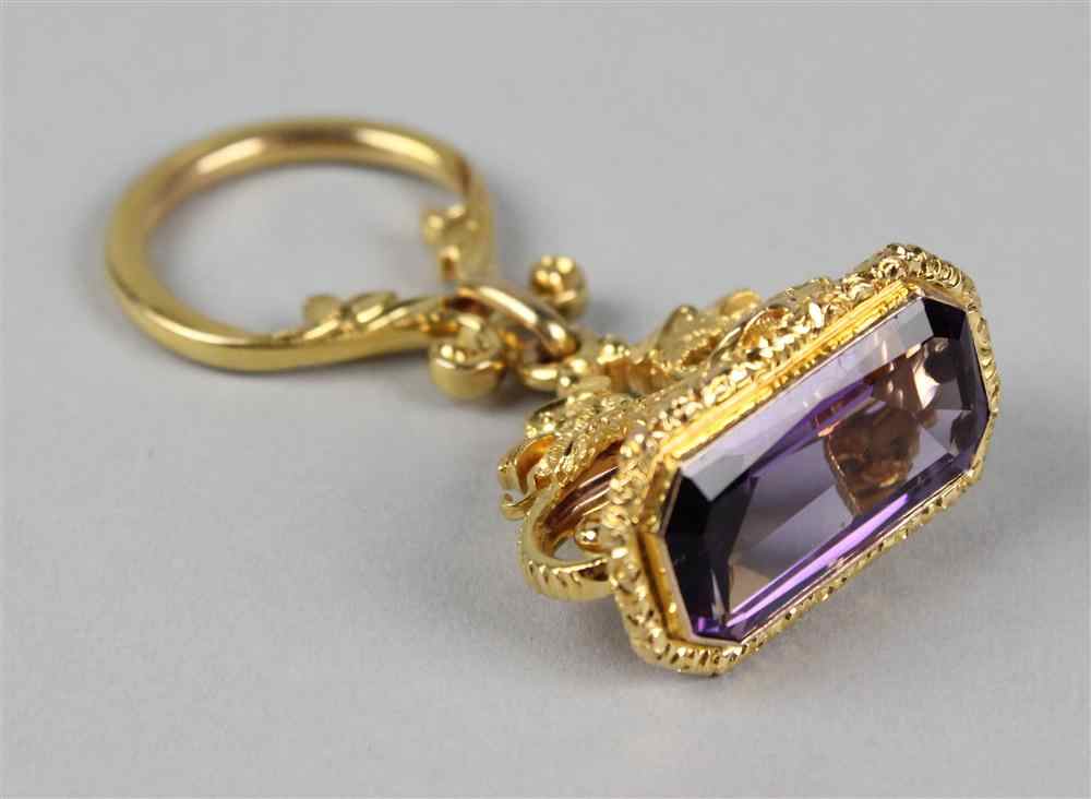 Appraisal: ADAM-STYLE GOLD AND AMETHYST FOB the narrow rectangular faceted stone