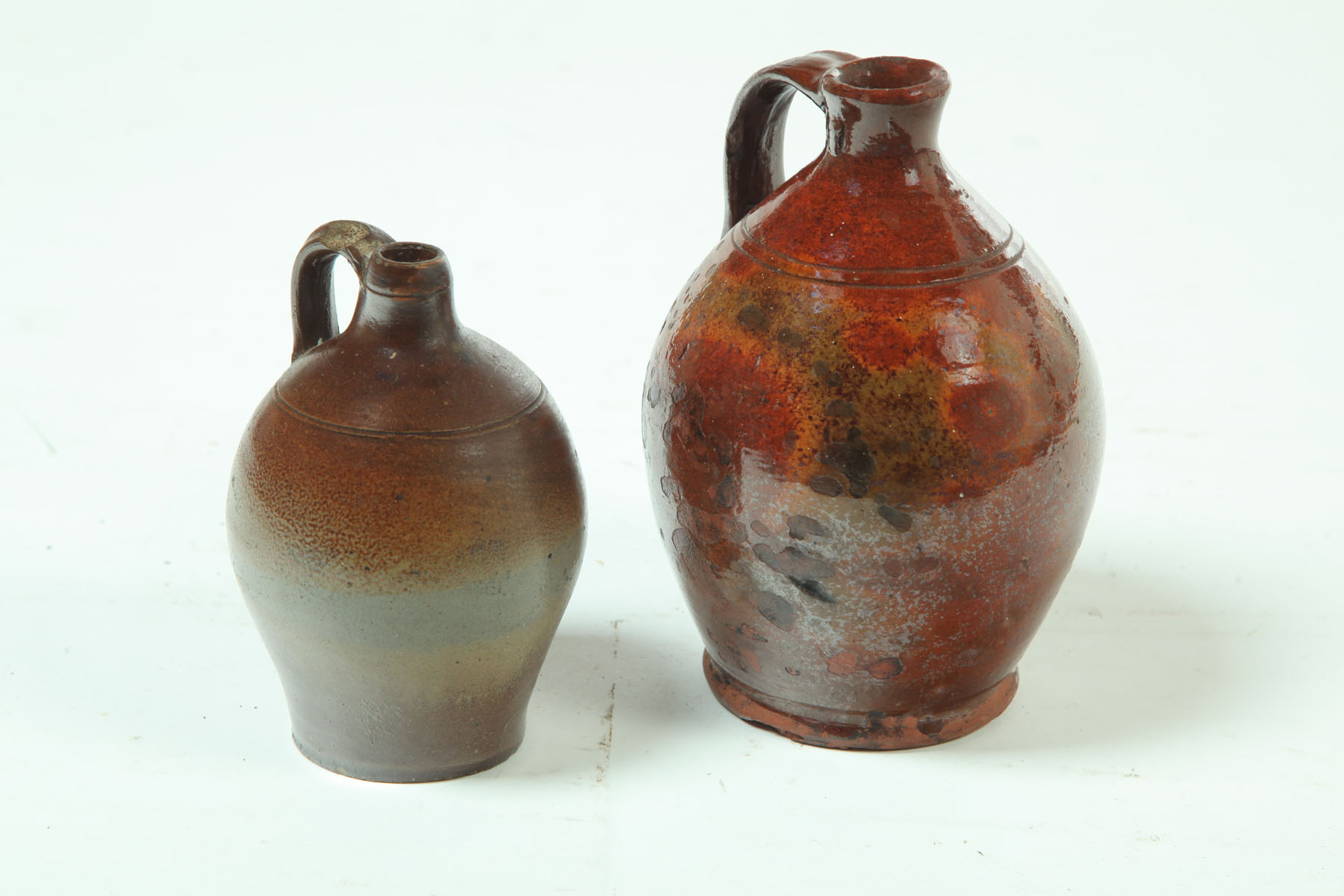 Appraisal: TWO SMALL JUGS American mid th century Redware with mottled