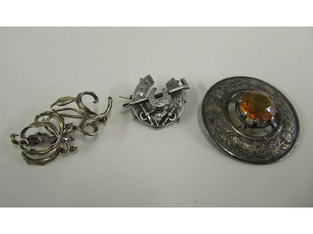 Appraisal: Lot comprising a silver horseshoe brooch silver thistle brooch and