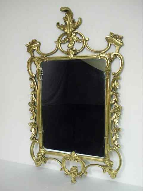 Appraisal: Ornately carved gold gilt mirror Carved wood gilt frame Condition