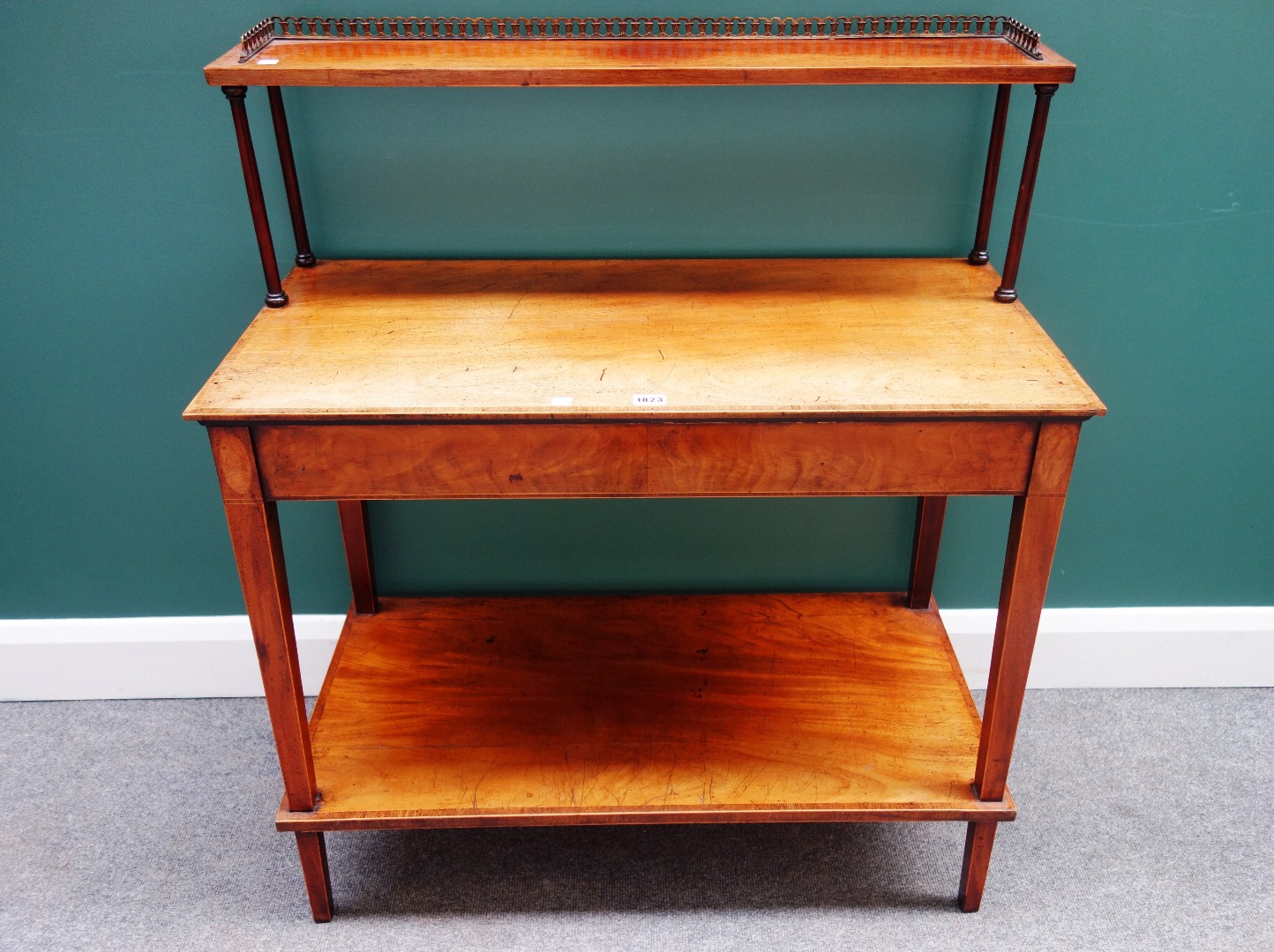 Appraisal: An inlaid mahogany side table the open shelf back over