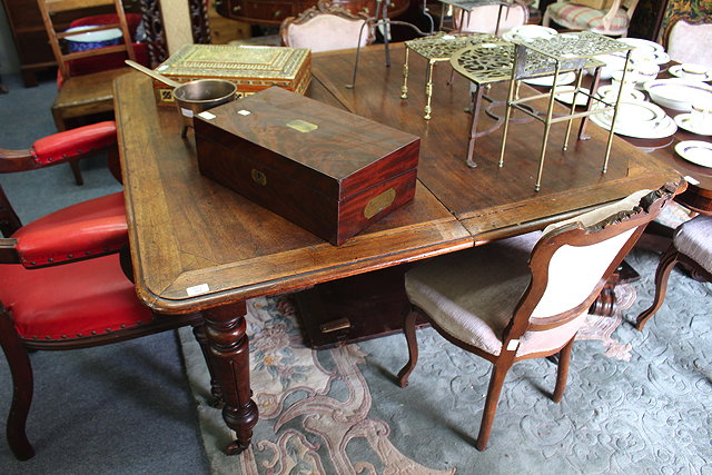 Appraisal: AN ANTIQUE MAHOGANY WIND OUT EXTENDING DINING TABLE with extra