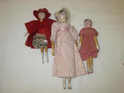 Appraisal: Three wooden peg dolls with painted faces on jointed peg