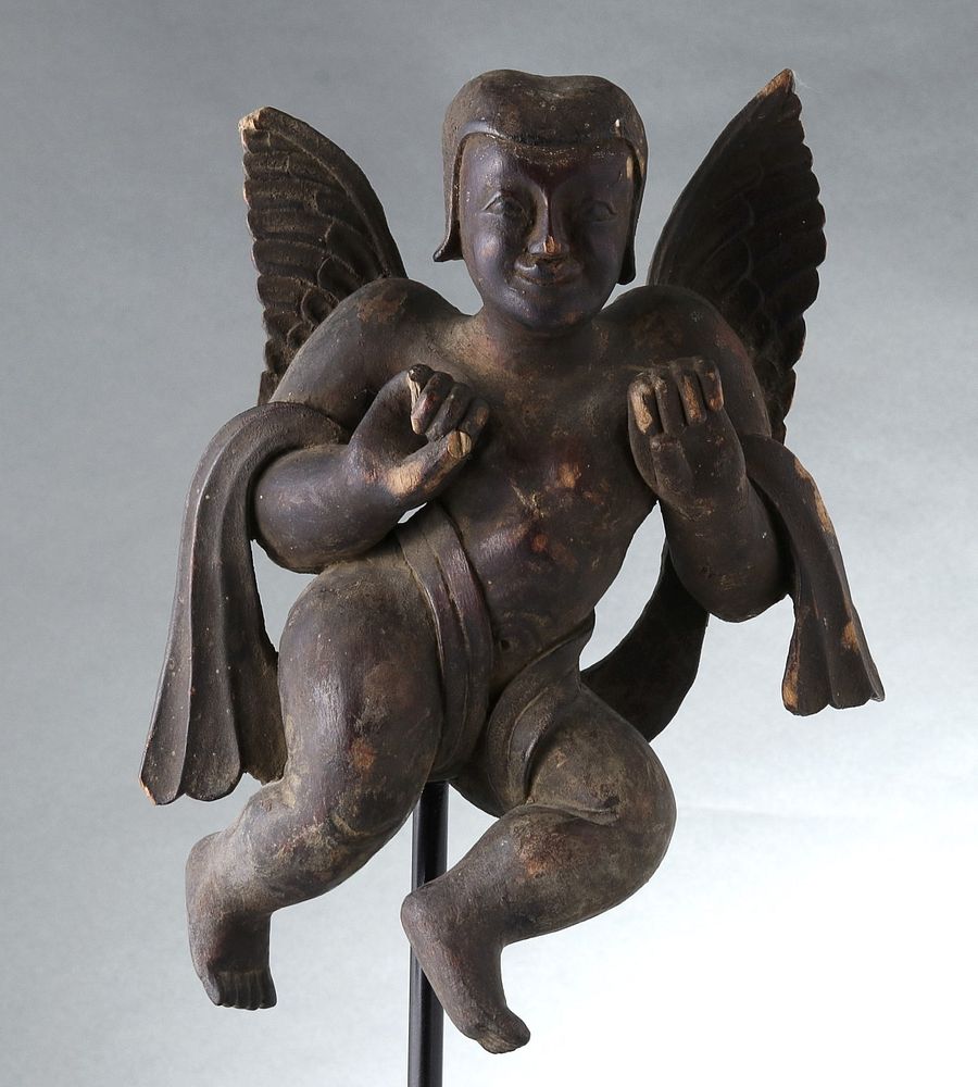 Appraisal: A PRIMITIVE WOOD CARVING OF AN ANGEL The stylized depiction