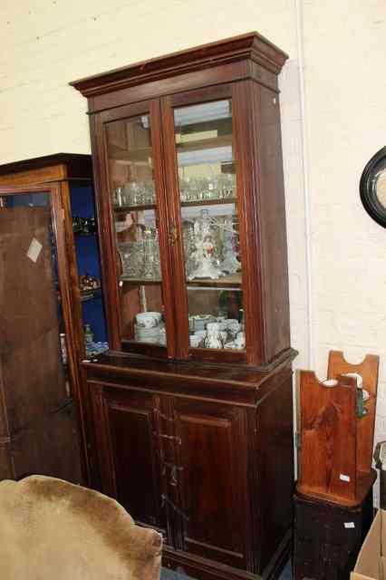 Appraisal: A LATE VICTORIAN MAHOGANY BOOKCASE CABINET with glazed doors above