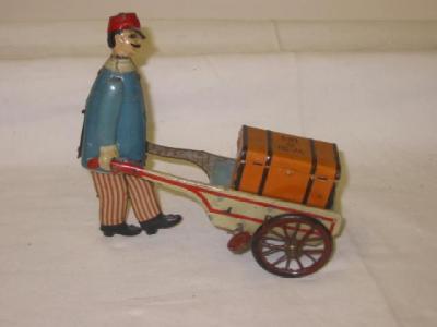 Appraisal: A Marke Stock railway porter toy tinplate porter and barrow