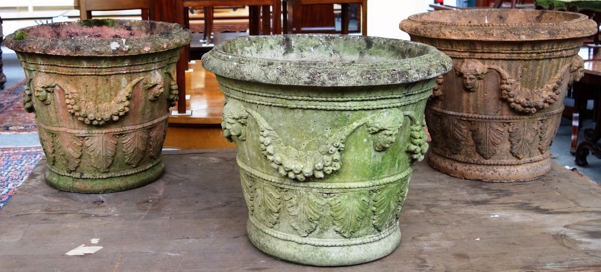 Appraisal: A set of three reconstituted stone tapering circular planters relief