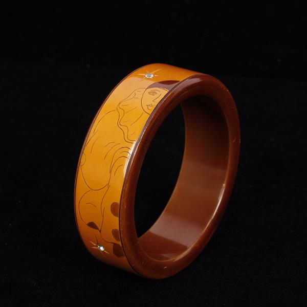 Appraisal: Art Deco s Bakelite two tone bangle with etched Harlequin