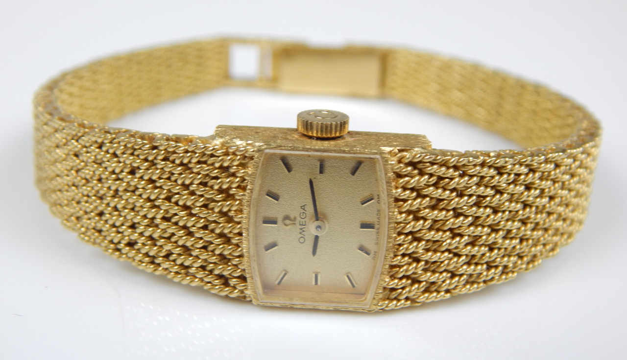 Appraisal: An Omega ladies wristwatch with crossover woven bracelet yellow metal