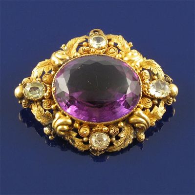 Appraisal: A Victorian gold brooch centred with an oval shaped amethyst