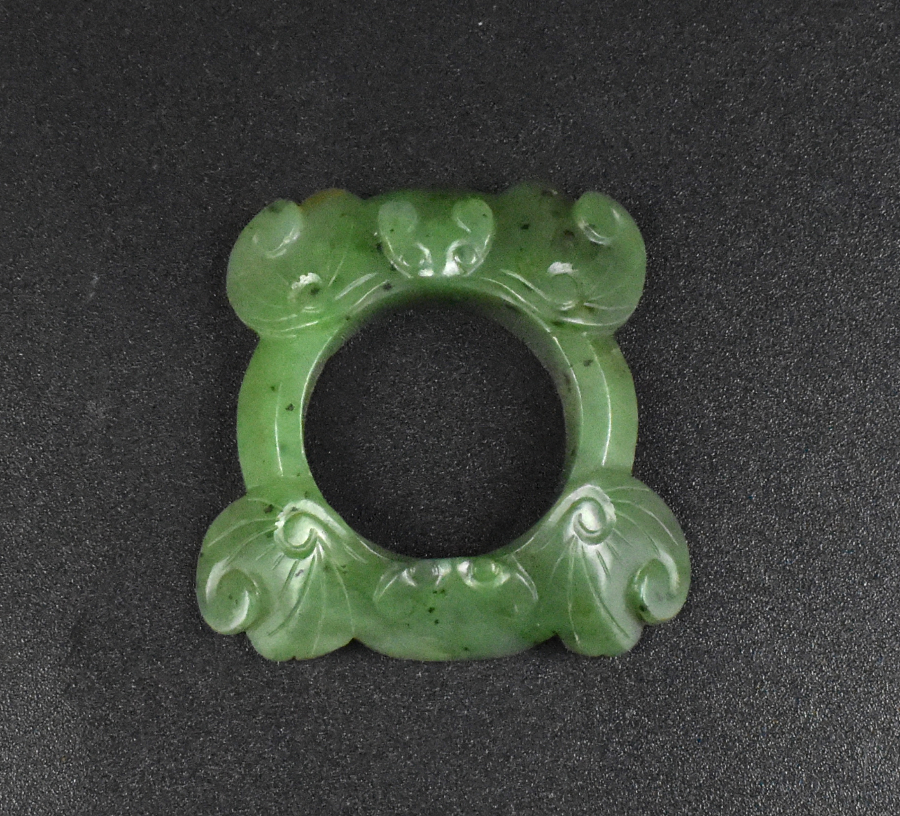 Appraisal: A Chinese spinach jade carved loop with bat design Qing