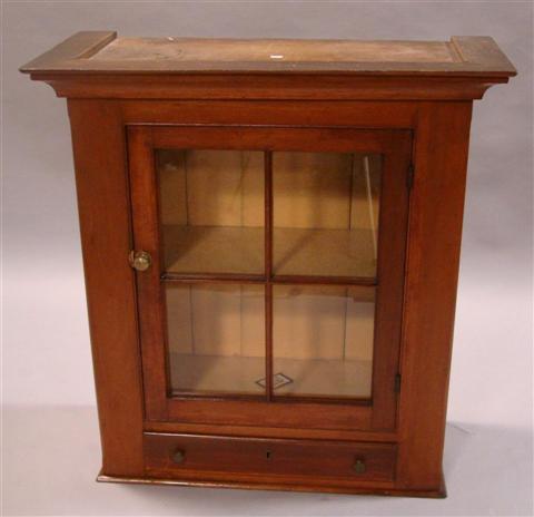 Appraisal: AMERICAN CHERRY HANGING CUPBOARD the shaped cornice over single paned