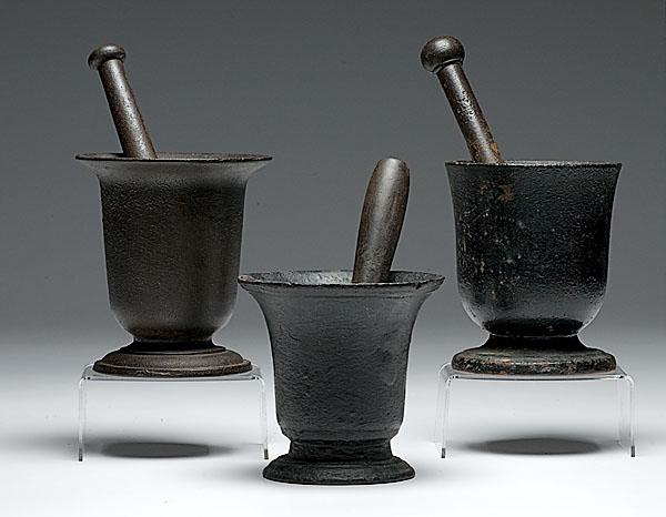 Appraisal: THREE LARGE CAST IRON MORTARS AND PESTLES ranging in size