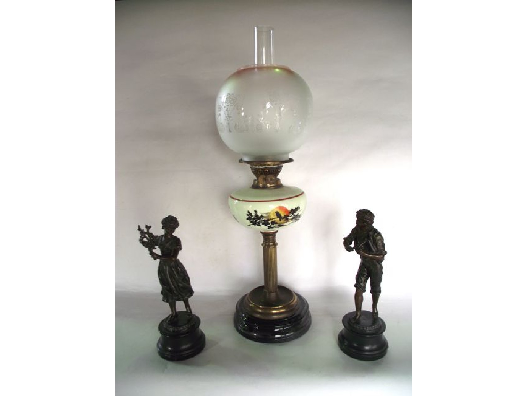 Appraisal: An oil burning lamp raised on a brass fluted column