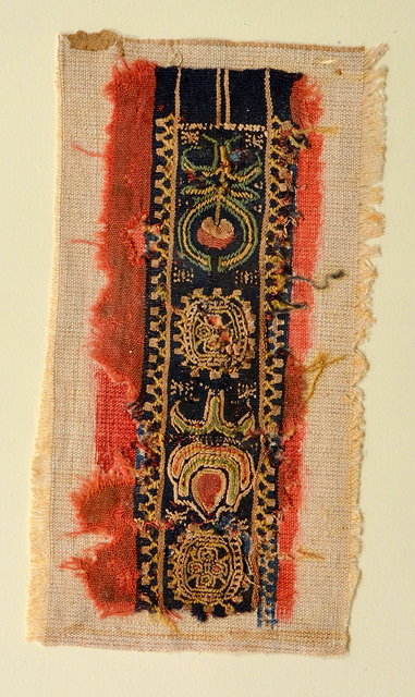 Appraisal: AN EMBROIDERED RECTANGULAR PANEL with stylistic fruit and symbolic motif