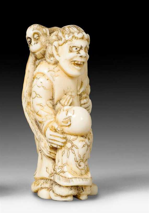 Appraisal: AN IVORY NETSUKE OF A SARUMAWASHI WITH A BOY Japan