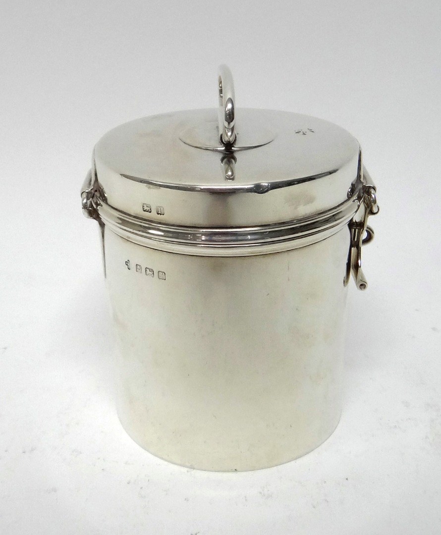 Appraisal: A silver cylindrical hinge lidded box the lid with a