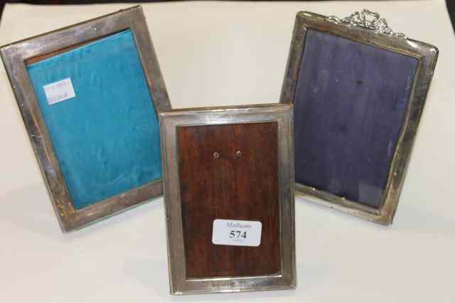 Appraisal: THREE SILVER PHOTOGRAPH FRAMES of plain form one with ribbon