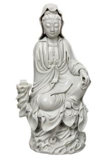 Appraisal: A BLANC-DE-CHINE FIGURE OF GUANYIN ON A ROCK the goddess