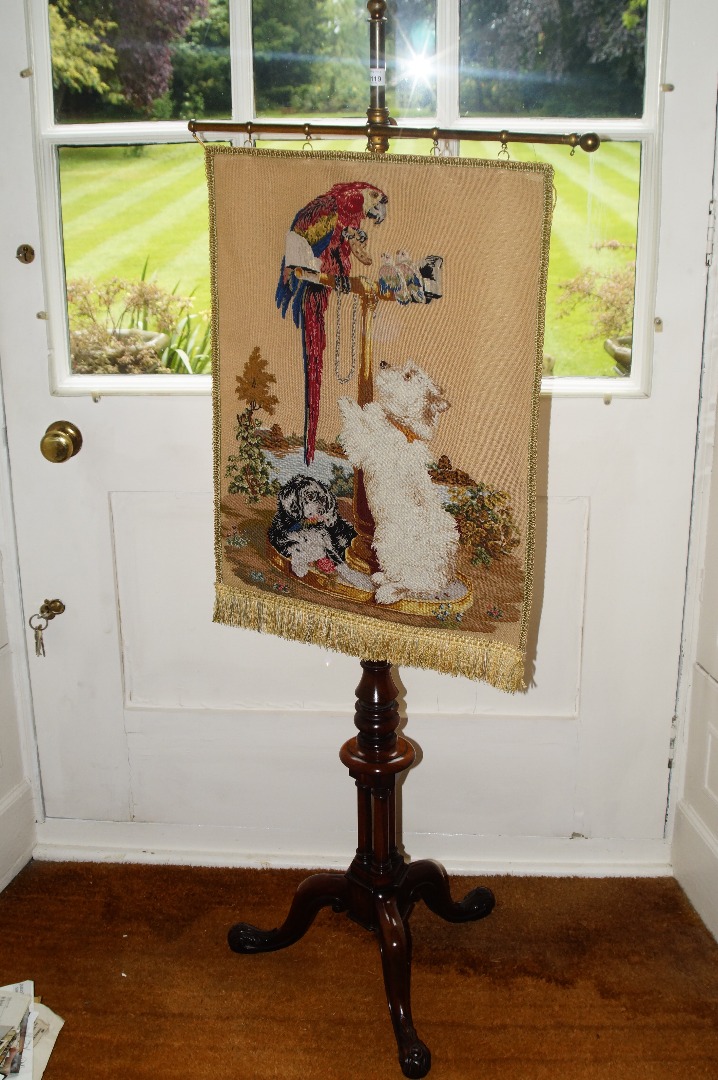 Appraisal: A Victorian walnut pole screen with a later banner depicting