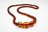 Appraisal: NECKLACE - A continuous strand of oval amber beads graduating