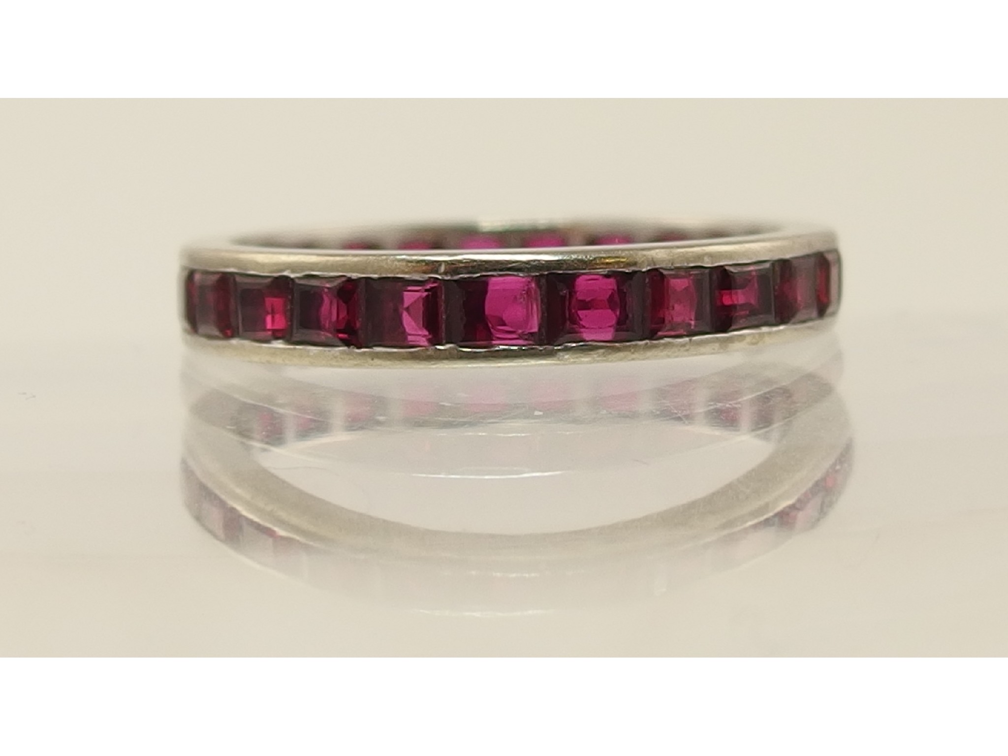 Appraisal: A white metal eternity ring set with red gem stones