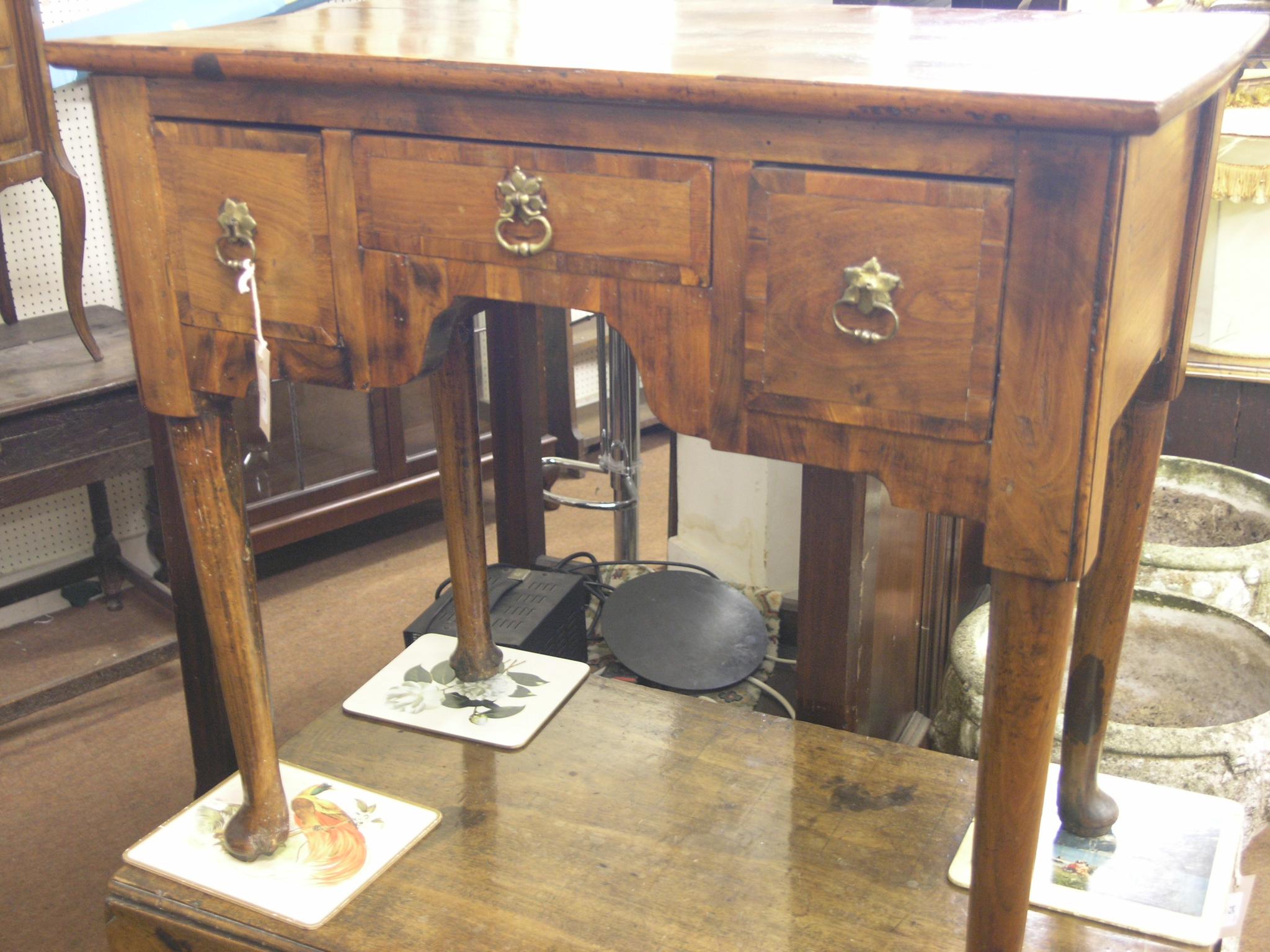 Appraisal: A walnut lowboy th century with repairs cross-banded top above