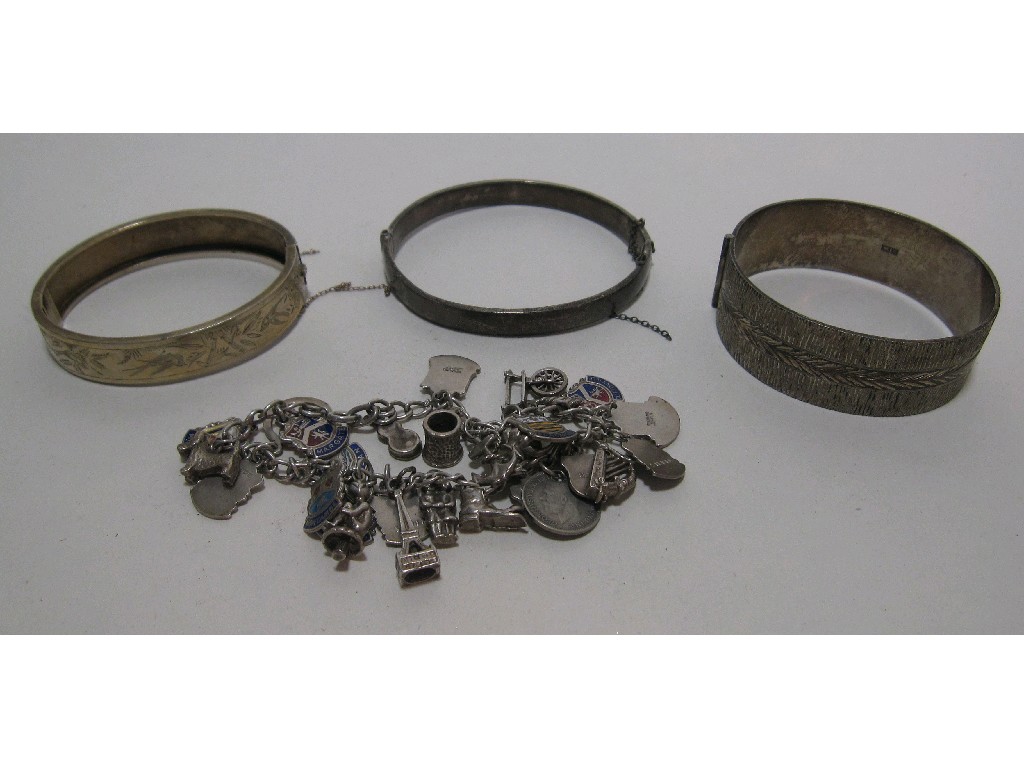 Appraisal: Lot comprising three silver bangles and a silver charm bracelet