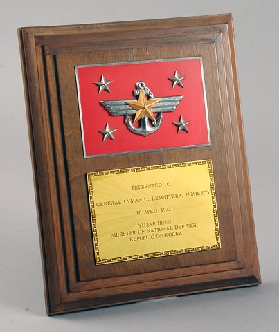 Appraisal: Wood presentation plaque featuring metal insignia of the Minister of