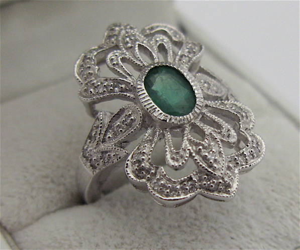 Appraisal: EMERALD DIAMOND AND KARAT WHITE GOLD RING centering an oval-cut