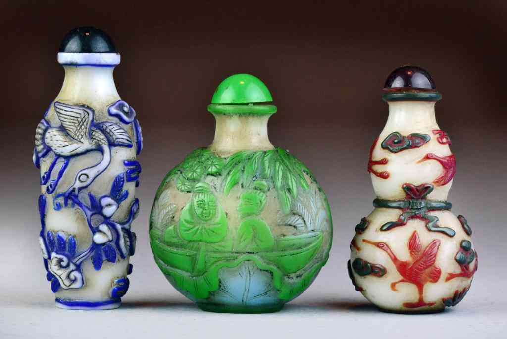 Appraisal: Chinese Peking Glass Snuff BottlesCarved to depict figures and phoenix