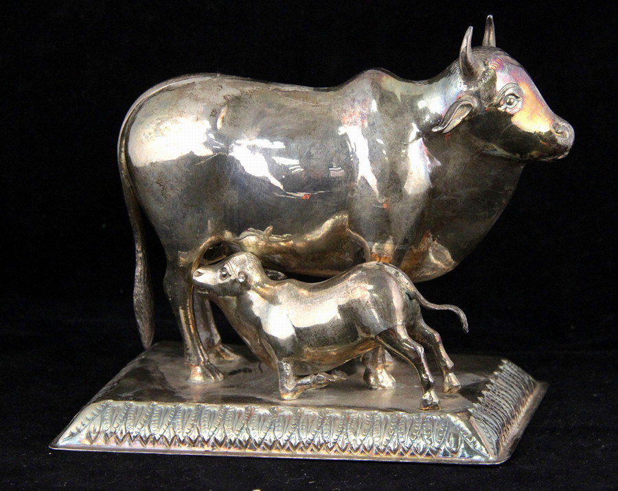 Appraisal: An Indian white metal figure of a cow with calf