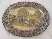 Appraisal: A white metal oval dish with paper print of coaches