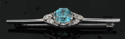 Appraisal: A zircon and diamond brooch The round blue zircon centrally