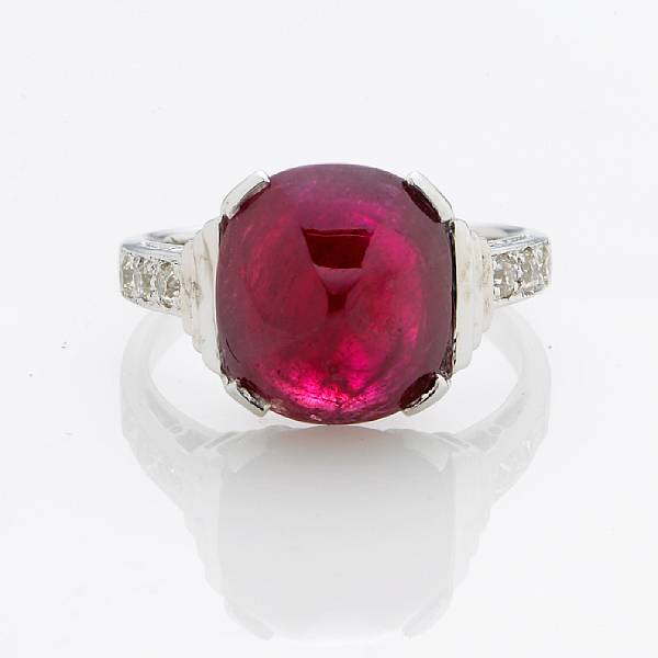 Appraisal: A ruby and diamond ring centering a sugarloaf-cut ruby cabochon