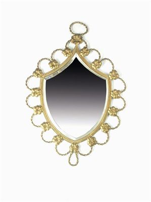 Appraisal: A brass framed shield shaped wall mirror with a bevelled