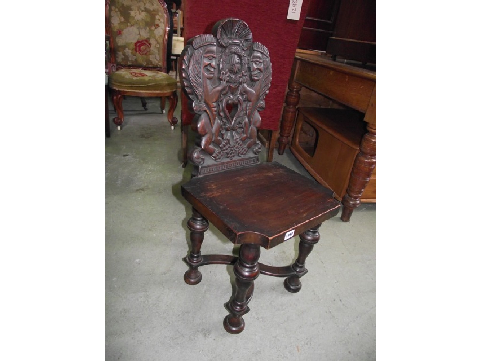 Appraisal: A stained walnut hall chair with shield shaped back carved