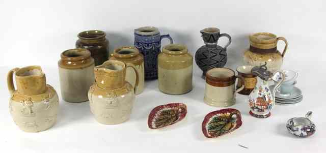 Appraisal: Three stoneware jugs with raised decoration including drinkers huntsmen etc