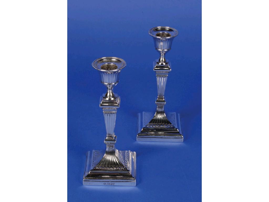 Appraisal: A PAIR OF EDWARDIAN CANDLESTICKS with tapering fluted stems urn