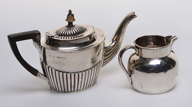 Appraisal: AN EDWARDIAN SILVER TEAPOT with reeded lower body matching domed