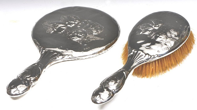 Appraisal: A SILVER BACKED HAIRBRUSH with embossed cherub decoration together with