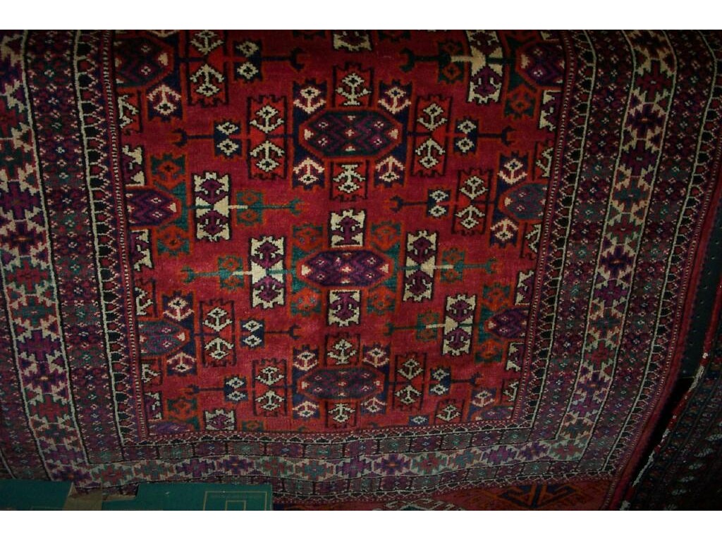 Appraisal: A red ground Eastern wool rug in the Persian Bokhara